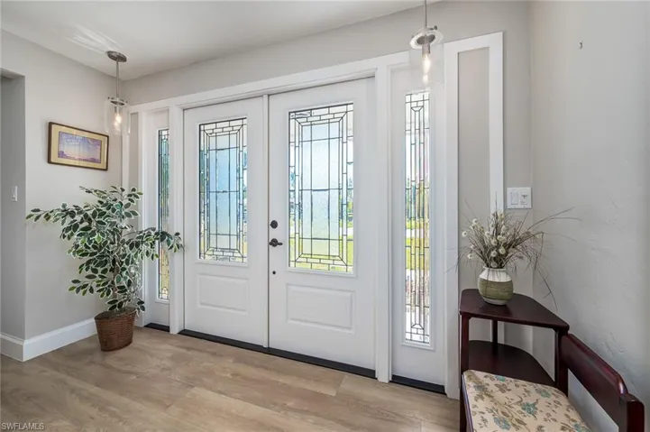 Foyer with French doors, baseboards, a wealth of natural light with LVP flooring.
