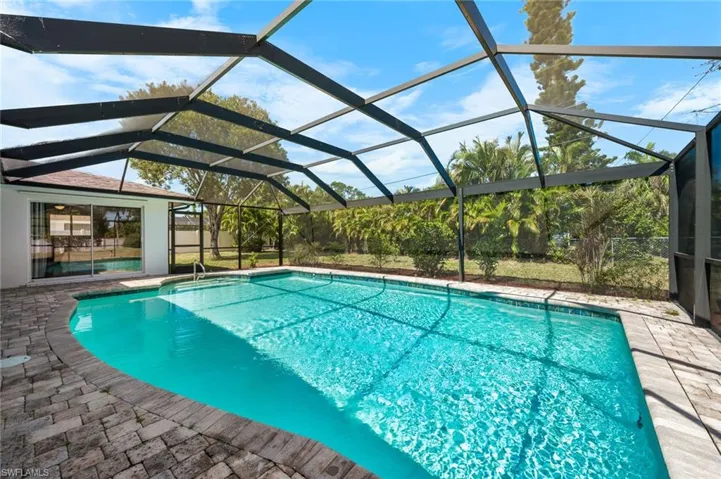 View of backyard from the pool area and slider to the guest bedroom.