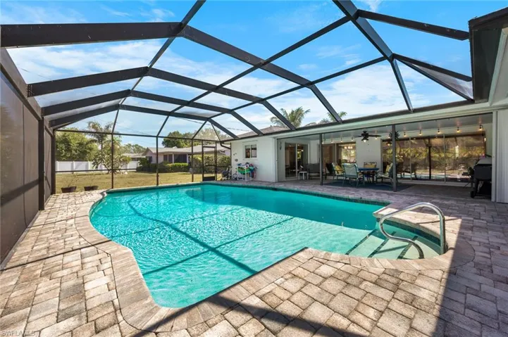 Screened in pool featuring large, covered lanai with accordion shutters and sliders to owner's suite, dining room & family room.