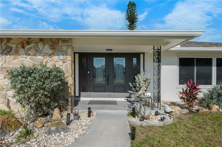 Front entry porch with French doors, stone siding & stucco.