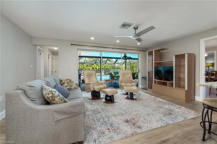 Family room with recessed lighting adjoins the kitchen and sliders lead to the lanai & pool.