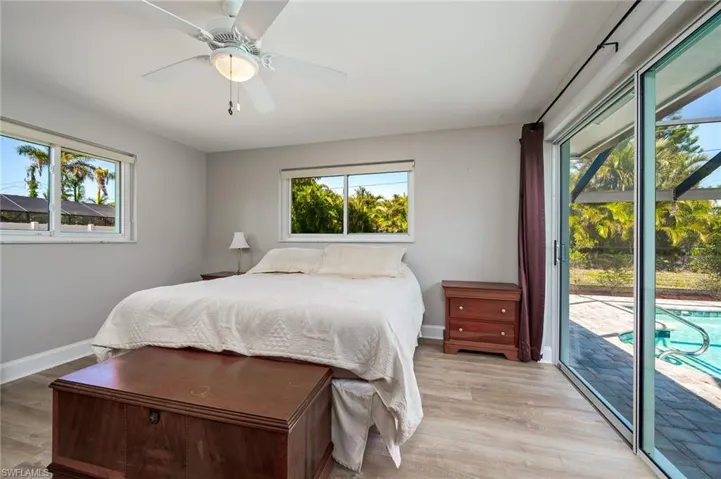 Guest bedroom features a closet, ceiling fan and sliders to the pool area and back yard.