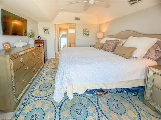 Bedroom featuring visible vents, lofted ceiling, and a ceiling fan