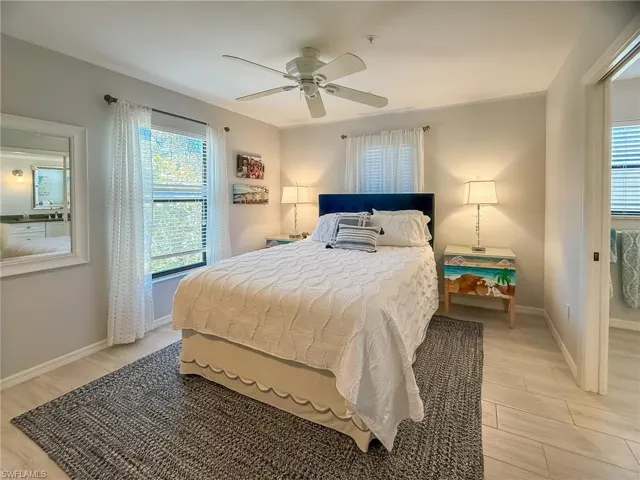 Bedroom with a ceiling fan, baseboards, and light wood-type flooring