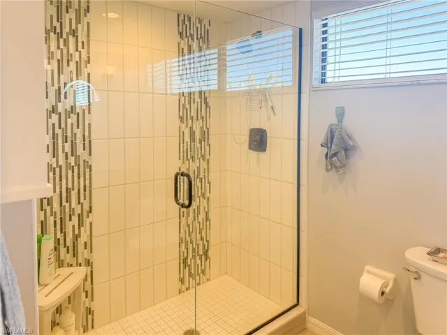 Full bath with a shower stall and toilet