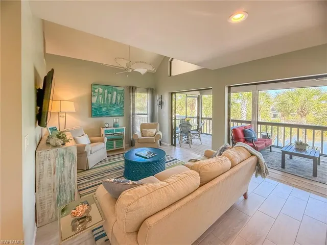 Living room featuring ceiling fan and vaulted ceiling