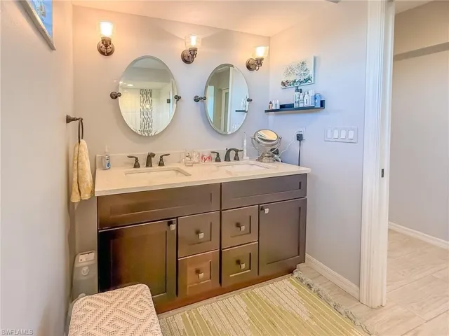 Bathroom featuring a sink, baseboards, and double vanity