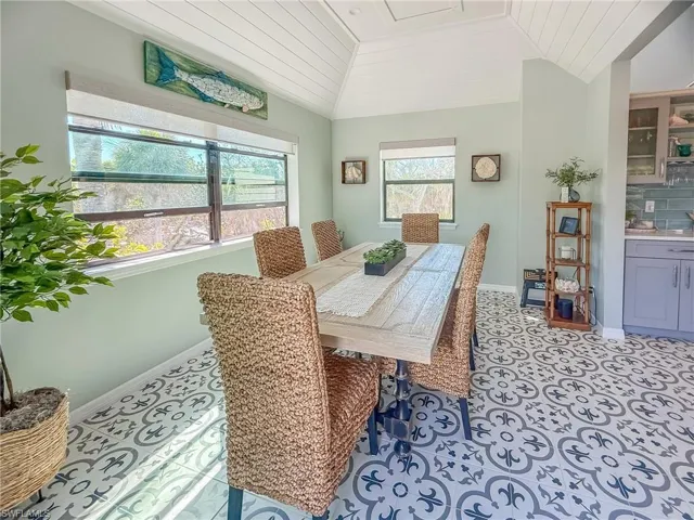 Dining room featuring lofted ceiling, light tile patterned flooring, baseboards, and wooden ceiling