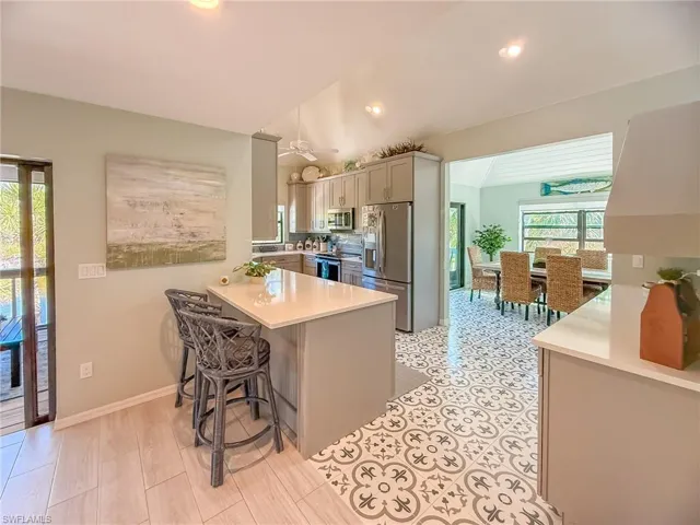 Kitchen featuring a breakfast bar area, a peninsula, light countertops, vaulted ceiling, and appliances with stainless steel finishes