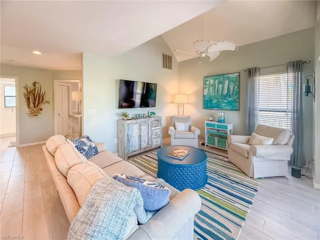 Living room featuring wood finished floors, a healthy amount of sunlight, and visible vents