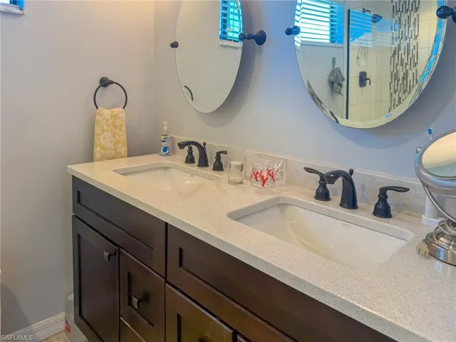 Bathroom featuring double vanity, a walk in shower, and a sink