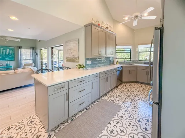 Kitchen featuring a peninsula, a ceiling fan, appliances with stainless steel finishes, and gray cabinetry