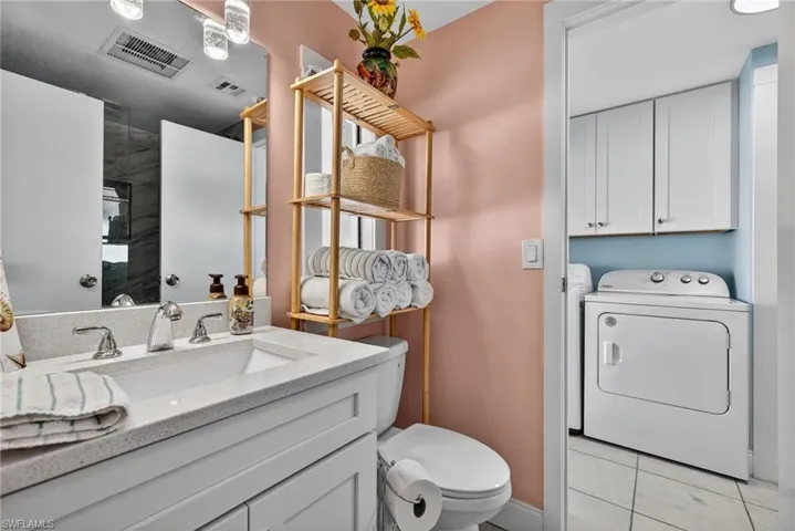 Bathroom featuring vanity, light tile patterned flooring, and a shower