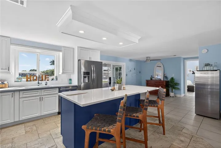 Dual tone kitchen featuring dual tone cabinetry, recessed lighting, backsplash, stainless steel appliances, and light stone counters