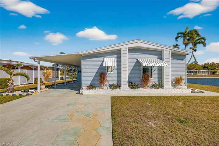 View of front of home featuring a front lawn, driveway, and a carport