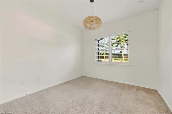 Empty room featuring light colored carpet and baseboards