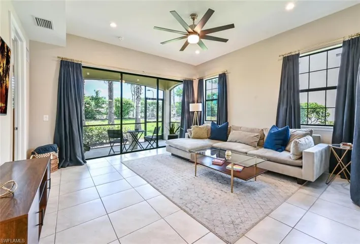 Living area with light tile patterned floors, recessed lighting, and a ceiling fan
