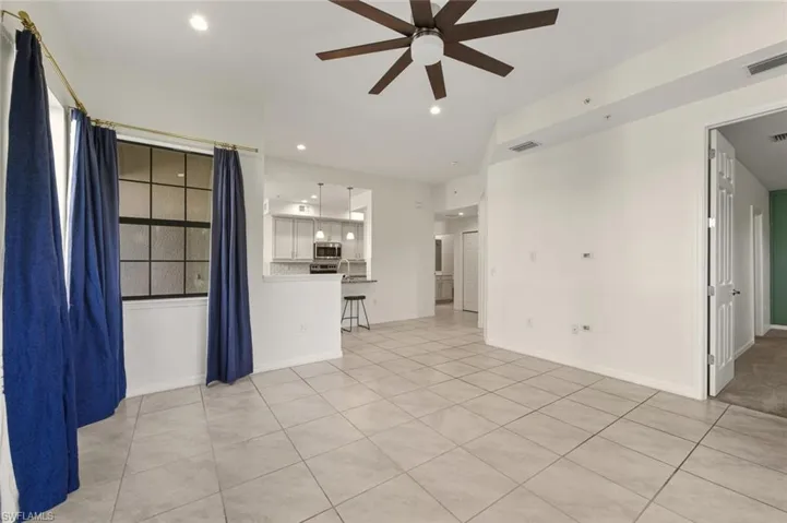 Unfurnished living room with light tile patterned floors, ceiling fan, and recessed lighting