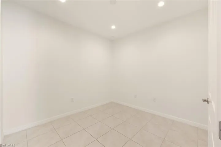 Empty room with recessed lighting and light tile patterned floors