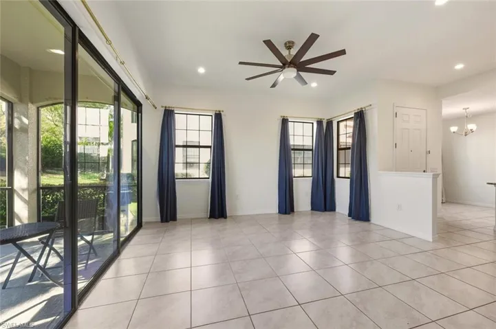 Spare room with a ceiling fan, light tile patterned flooring, recessed lighting, and a chandelier