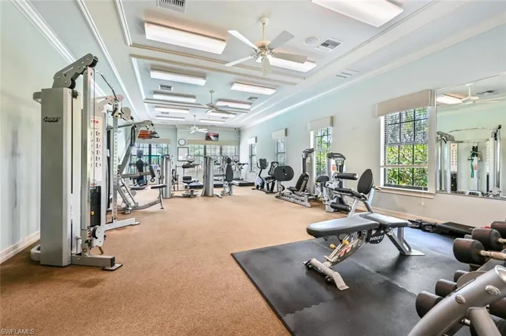 Gym with ceiling fan and crown molding