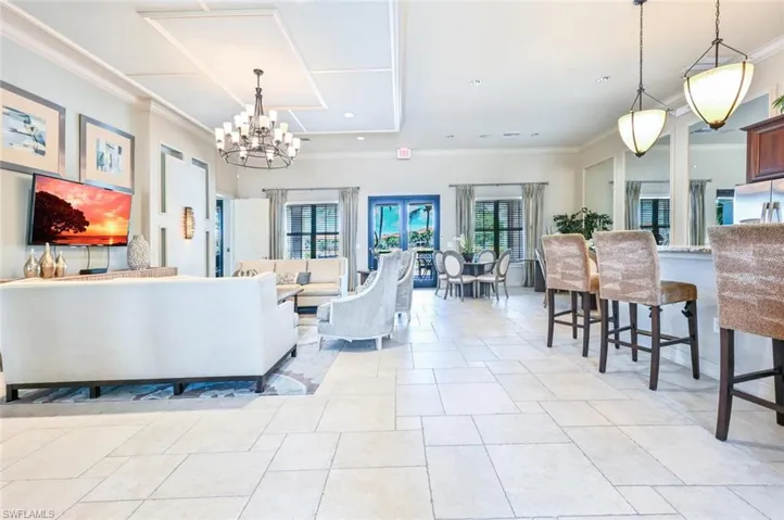Living room with a chandelier, recessed lighting, light tile patterned floors, and crown molding