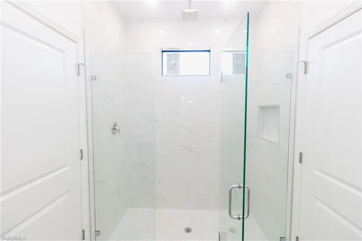 Full bathroom with a marble finish shower