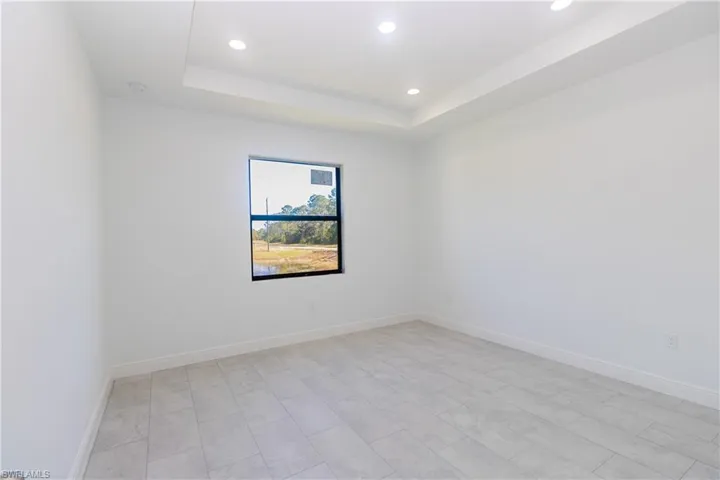 Unfurnished room with a raised ceiling and recessed lighting