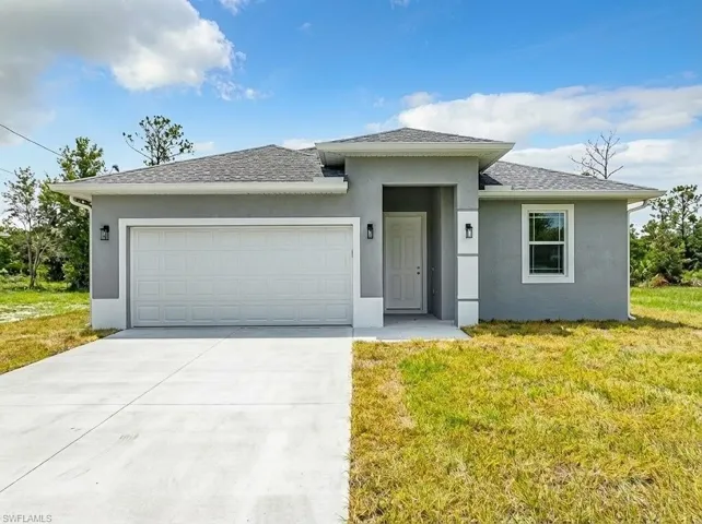 View of front of house featuring stucco siding, a front lawn, a shingled roof, driveway, and an attached garage