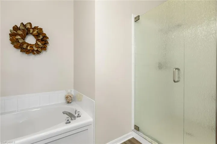 Separate soaking tub and a walk in shower with a seamless glass enclosure.