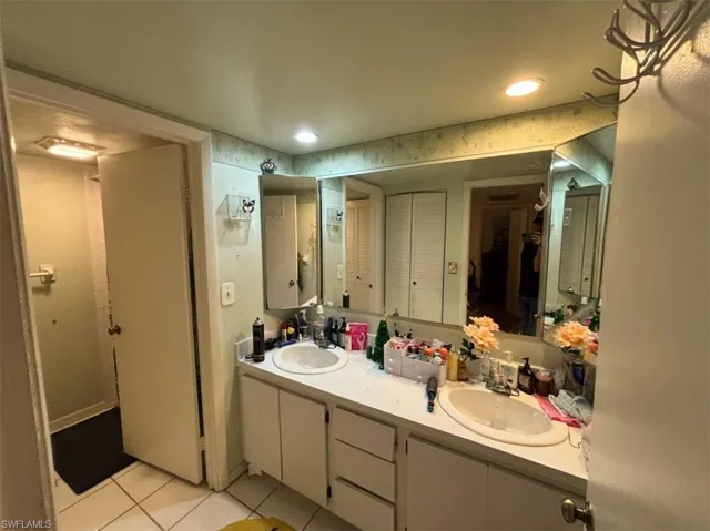 Bathroom with tile flooring, double sink, and large vanity