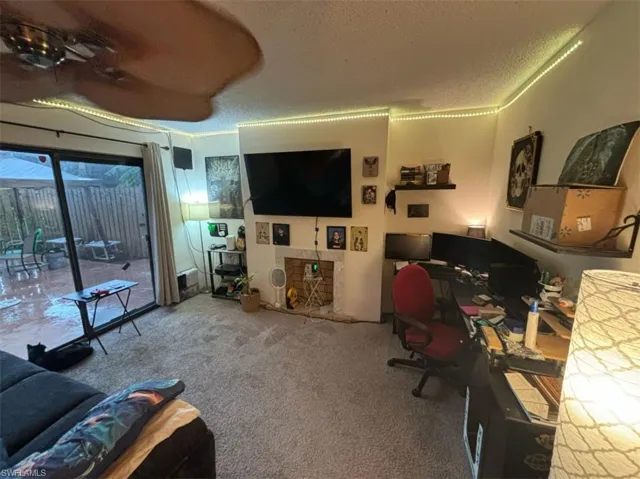 Office area featuring a textured ceiling, carpet floors, and ceiling fan