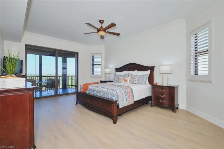 Bedroom featuring ornamental molding, light wood-type flooring, and access to exterior