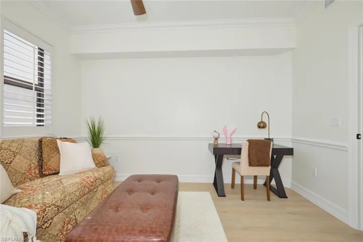 Living room with crown molding, baseboards, visible vents, and light wood-style floors