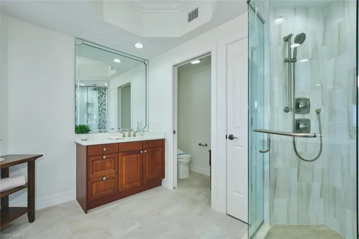 Bathroom featuring vanity, toilet, recessed lighting, visible vents, and a stall shower