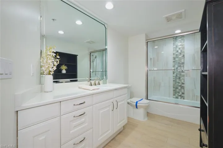 Bathroom with visible vents, vanity, wood finished floors, toilet, and recessed lighting