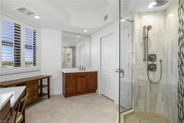 Bathroom with vanity, an enclosed shower, and ornamental molding