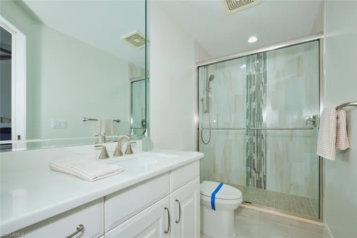 Bathroom with visible vents, tile patterned flooring, a stall shower, and toilet