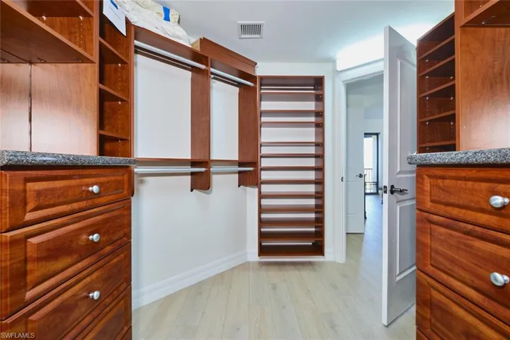 Walk in closet with light wood-style floors and visible vents