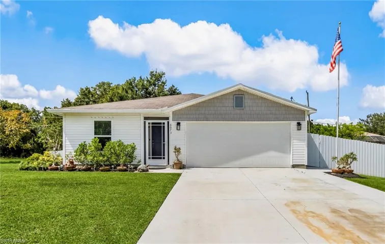 Ranch-style house featuring concrete driveway and a garage