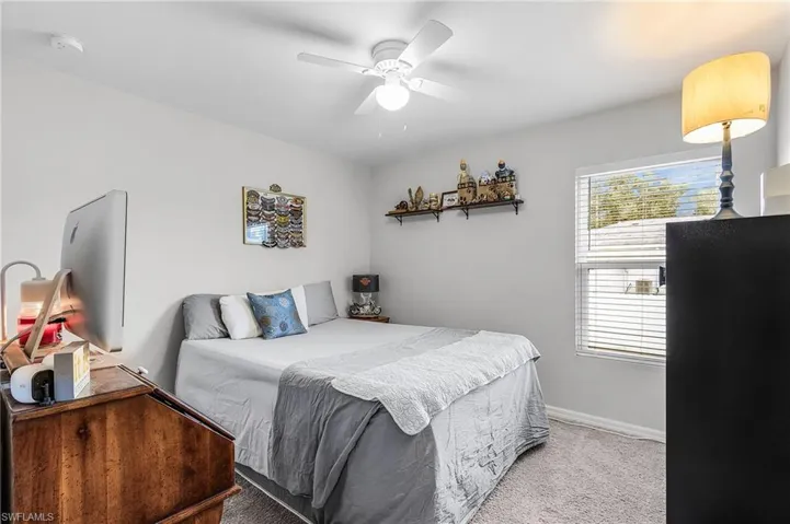 Carpeted bedroom featuring a ceiling fan and baseboards