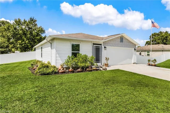 Single story home with concrete driveway and a garage