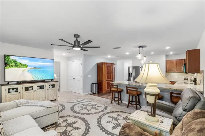 Living area with ceiling fan and baseboards