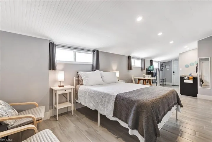 Open-concept room featuring wood-finish flooring, recessed lighting, and a beadboard ceiling