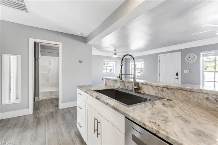 Kitchen island featuring a stainless steel undermount sink and a gooseneck faucet