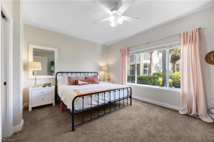 Carpeted bedroom featuring ceiling fan