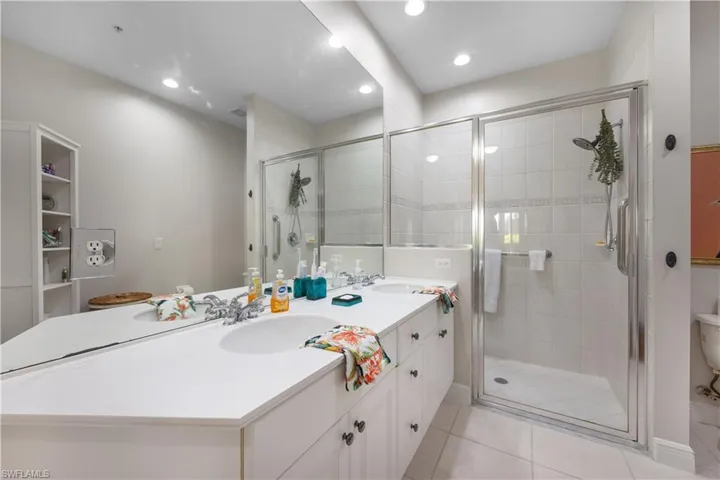 Bathroom featuring vanity, tile patterned floors, and an enclosed shower