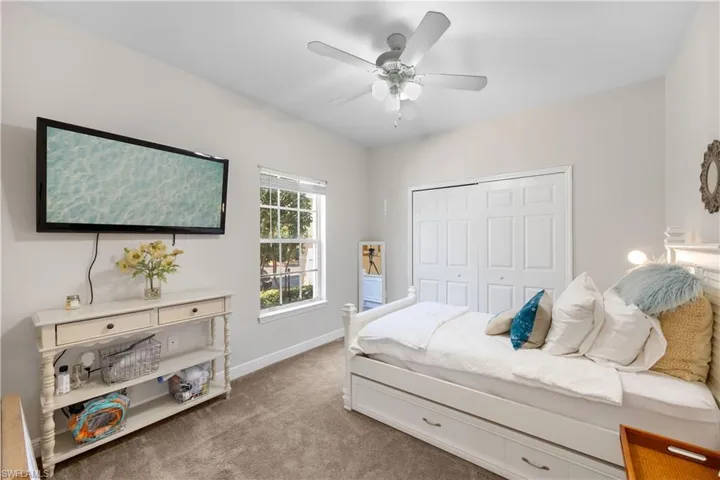Carpeted bedroom with a closet and ceiling fan
