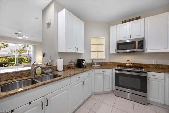 Kitchen featuring ceiling fan, white cabinetry, sink, and appliances with stainless steel finishes