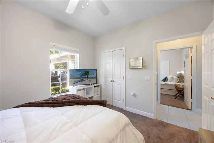 Bedroom featuring ceiling fan, a closet, and light carpet